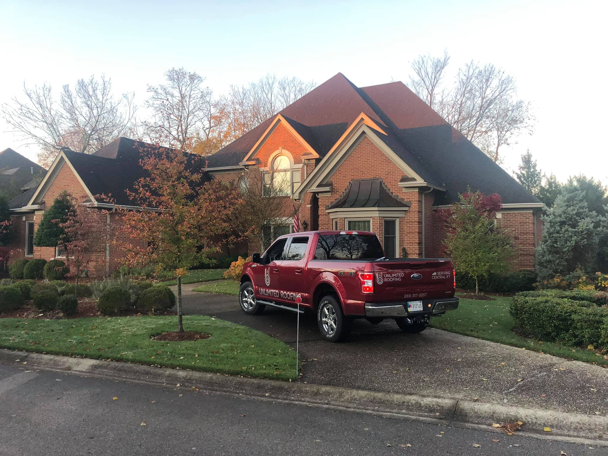 Insured Roofing Contractor - Red Truck in Driveway of Nice Home with New Roof